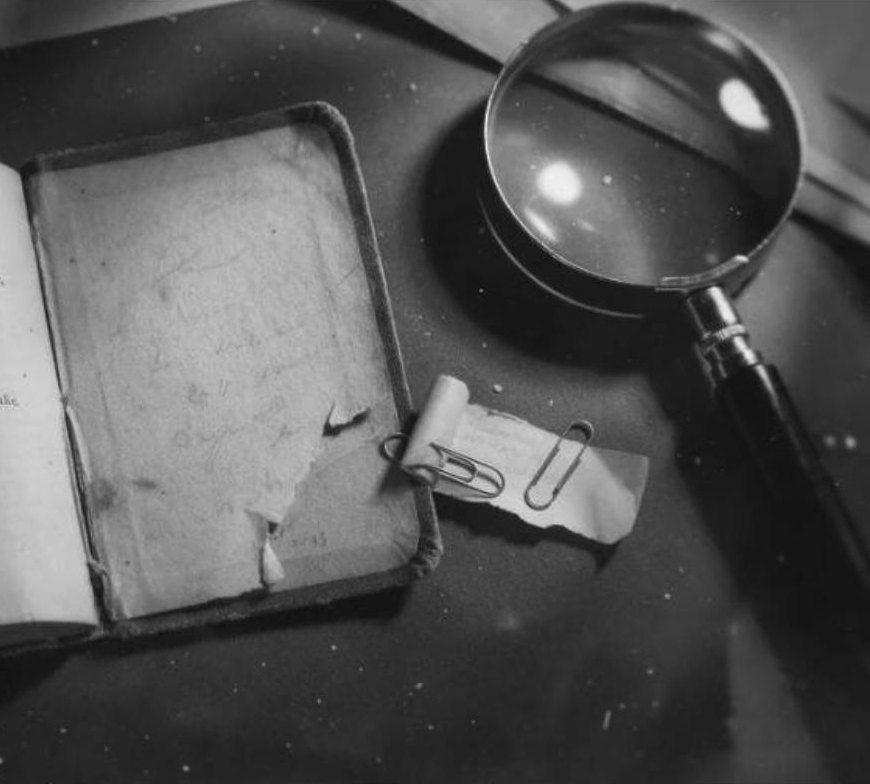 Reconstruction: the book's torn back page with a rolled scrap of paper and a magnifying glass