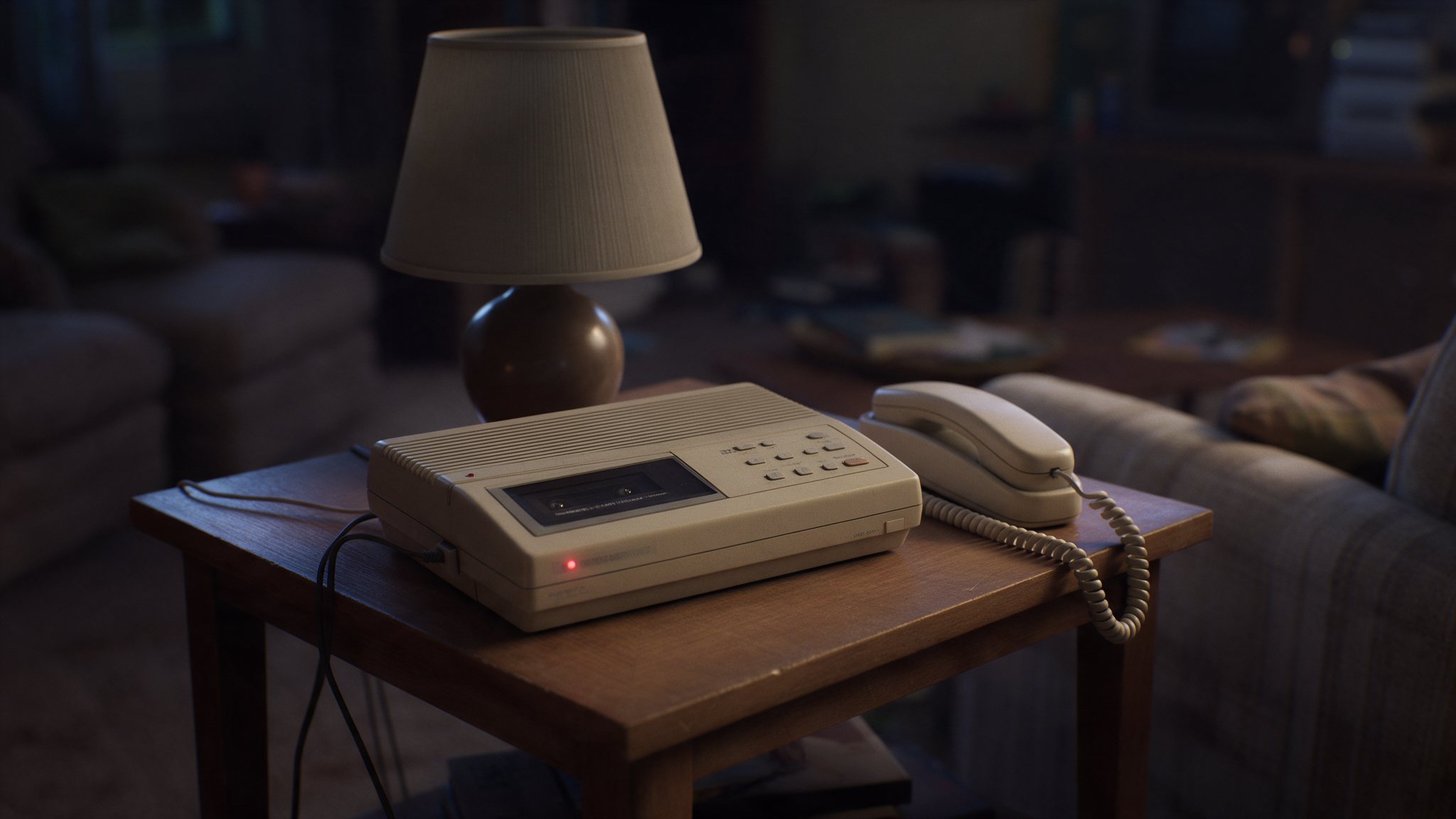 Reconstruction: an early-1990s answering machine on a side table in a dark living room, its message light glowing